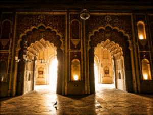Interior view of a historic Nawabi monument in Lucknow featuring ornate arches, intricate architectural details, and light-filled corridors showcasing Awadhi heritage craftsmanship.