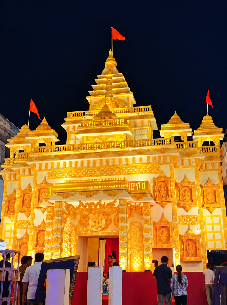 Patrakarpuram Ke Bappa, a beautifully illuminated Lord Ganesha pandal in Lucknow, designed like an ornate golden temple with multiple towers, saffron flags and devotees gathered outside at night.